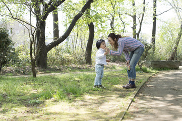 Obraz premium Young boy is trying to eat something in the park