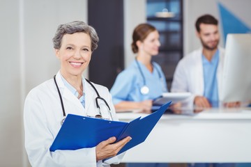 Portrait of happy female doctor holding medical reports 