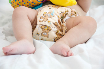  baby in modern eco stacks of cloth diapers and replacement bushings selective focus close-up on...