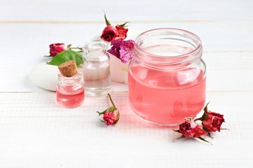 Aroma rose water for skincare, essential oils, jar and bottle, dried flowers. 
