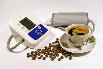 Arabica coffee beans and cup of black coffee, tonometer for meas