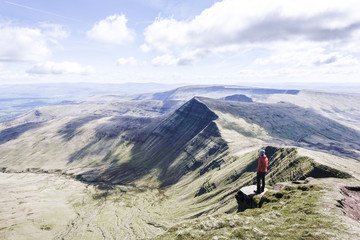 Fototapeta A girl on top of a mountain looking at the panorama, Pen Y Fan obraz