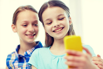 happy girls with smartphone taking selfie at home