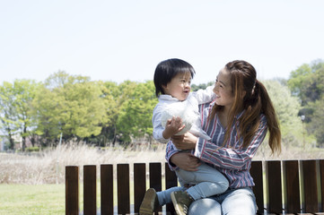 Mother and son sitting on a bench in the park