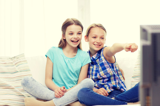 Two Happy Little Girls Watching Tv At Home