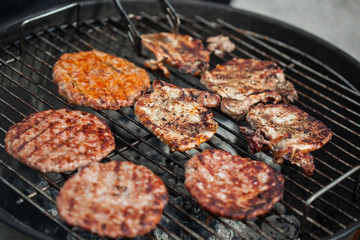 Steaks and burgers on BBQ oven