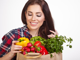 Isolated woman holding a shopping bag full of vegetables