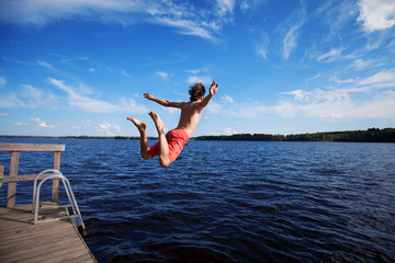 Young man jumping into water - Powered by Adobe