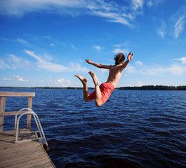 Young man jumping into water