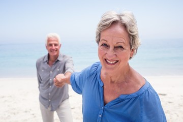 Happy senior couple holding hand on the beach