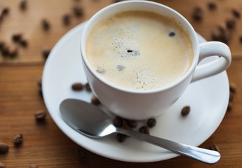 close up coffee cup and grains on wooden table