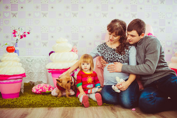 Parents play with a beautiful daughter and a dog
