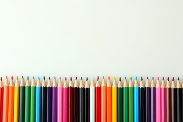 a lot of colored pencils lying next to each other on a white isolated background
