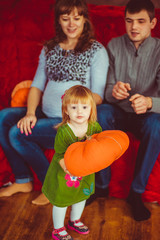 Little girl is holding an orange pillow