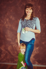 Fototapeta premium Beautiful pregnant woman and her little daughter
