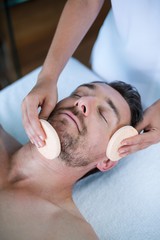 Fototapeta na wymiar Man receiving a facial massage from masseur 