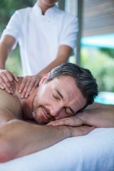 Man receiving back massage from masseur