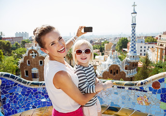 Naklejka premium Uśmiechnięta matka i dziecko robienia zdjęć aparatem w Park Guell
