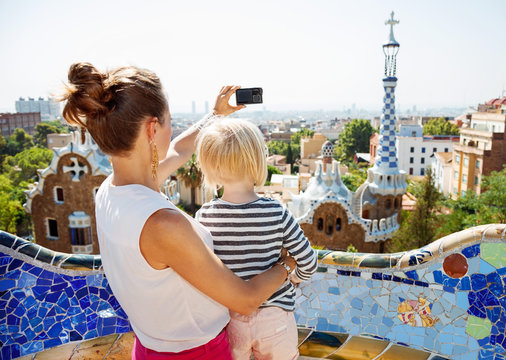 Mother and baby taking photos with digital camera at Park Guell