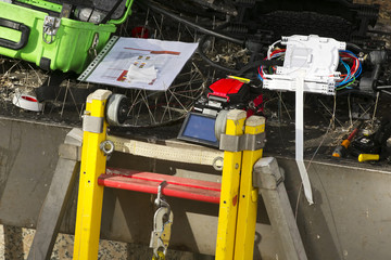 professional electrician worker with safety protective equipment  to install internet , tv and phone with optical fiber system in the building facade