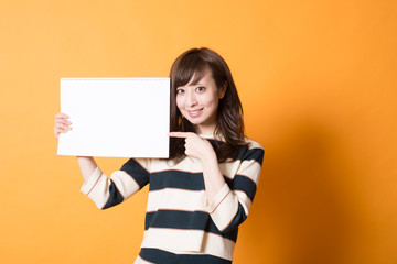 Fototapeta na wymiar 白いボードを掲げる日本人女性