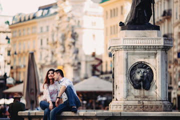 Fototapeta premium Couple in love sitting near fountain