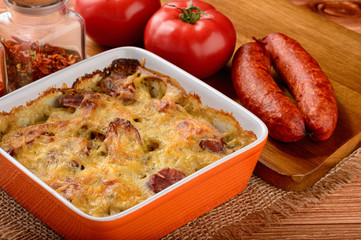 Casserole with potatoes, sausages, tomatoes and cheese.