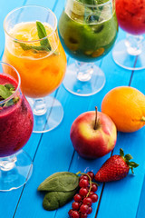 healthy colorful smoothies with fresh fruits on wooden background. Detox and diet food concept and background