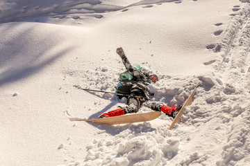 Female skier fallen into deep snow