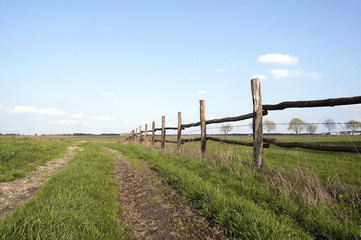Obraz premium Dirt road with a wooden fence