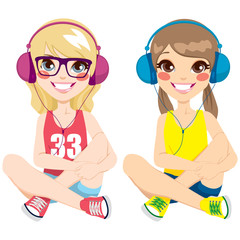 Two lovely teenager girls sitting on floor listening music with headphones together happy smiling