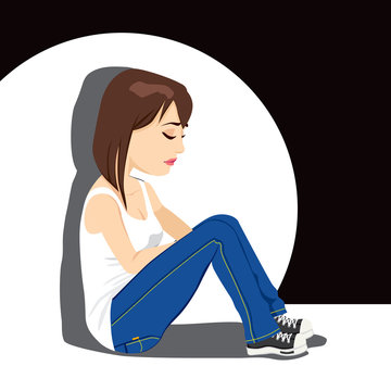 Sad teenager girl crying sitting on floor under white spot light on dark background