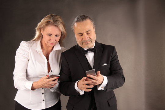 Mann und Frau beim Datenabgleich am Mobiltelefon