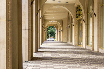 Archway in puppet-theatre building with tree and car in the end