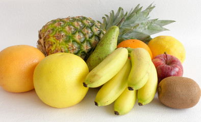 Composition of pineapple, baby bananas, grapefruits, apple, pear, orange, lemon and kiwi.