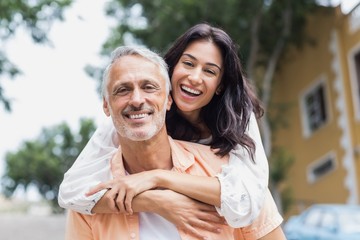 Naklejka premium Smiling woman hugging man from behind