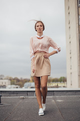 Beautiful girl walking on the building roof