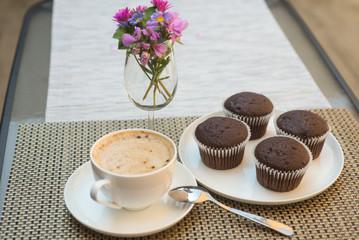 coffe with four chocolate muffins on table