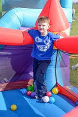 Fototapeta na wymiar Handsome little boy standing on a bouncy castle