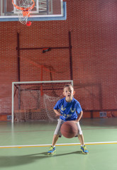 Sporty little boy playing basketball