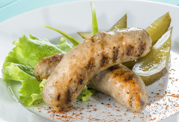 close-up hunting sausage of beef with pickled cucumber