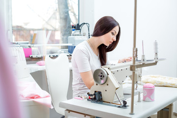 girl seamstress sew on the sewing machine