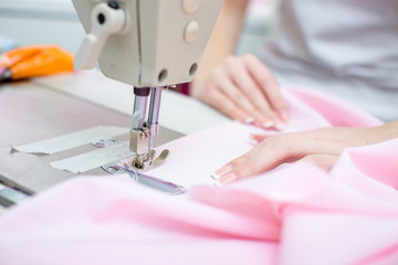 girl seamstress sew on the sewing machine