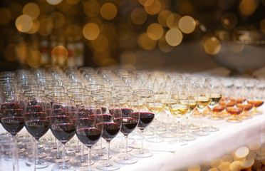 Glasses with different alcoholic drinks in bokeh