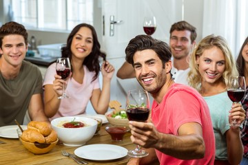 Portrait of happy friends holding wine glasses at table