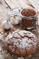 Loaf of bread, garlic and jar with buckwheat