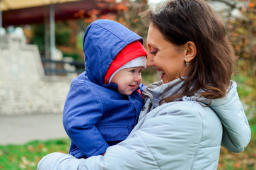 Fototapeta premium mother holding baby outdoors in autumn