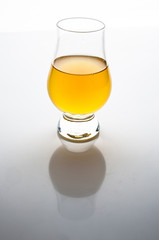 Apple vinegar in transparent glass on white background with reflection