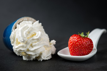 The whipped cream meets the strawberry in the spoon, minimalist style food