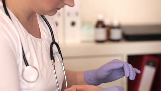 Eine junge Ärztin behandelt eine Wunde am Arm